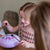 Child playing with a toy drum on a wooden table