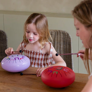 Child and adult playing with musical instruments at a table