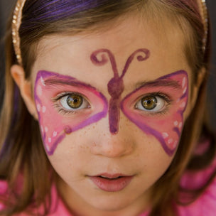 Child with butterfly face paint on a plain background