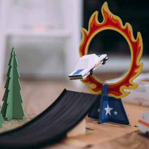 Model of a car on a track with a fire-themed obstacle