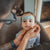 Person applying face paint to a child's face in a casual indoor setting