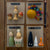 A flat-lay display of four educational wooden toy sets on brown cardboard sheets, arranged on a wooden surface. The sets are labeled 'King Autumn', 'Balance and Fall', 'Little Sprouts', and 'Soo in the Dark'.
