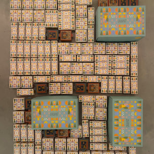 An overhead flat-lay view of a large collection of grapat collectible items, including multiple patterned boxes and smaller decorative boxes, arranged on a neutral gray surface.