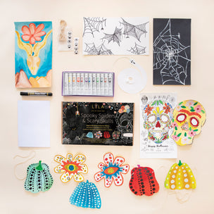 Lola Art supplies including coloring books, paint tubes, and craft materials on a beige surface.