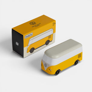 Yellow and white model of a Volkswagen bus next to its packaging box on a light gray background