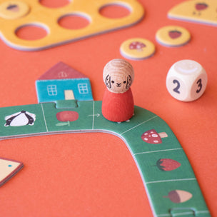 Children's board game with a character figure and dice on an orange surface