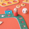 Children's board game with a character figure and dice on an orange surface
