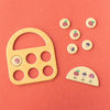 Wooden toy with various shaped pieces on a pink background