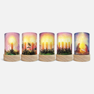 Five cylindrical LED pillar candles with wooden bases, each featuring a different nativity-themed illustration on the cylinder body, shown against a light gray background.