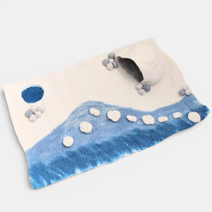 Felted blanket with blue and white patterns on a light gray background