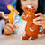 Child playing with a mouse and a gruffalo, on a wooden surface.