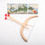 Wooden slingshot with red rubber bands on a white background, with images of dragons in the corner.