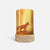 A cylindrical table lamp with a light wood base and a printed wraparound cylinder featuring a golden-yellow forest scene with a fox silhouette, shown on a clean white background.