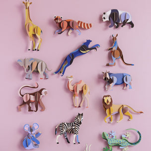 Collection of colorful animal figurines on a pink background