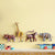 Wooden animal toys on a shelf against a yellow wall