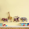 Wooden animal toys on a shelf against a yellow wall
