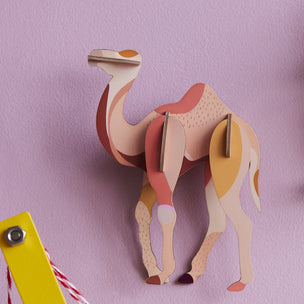 3D paper camel model on a pink background