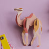 3D paper camel model on a pink background
