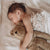 Child sleeping with a teddy bear on a soft surface