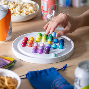 Colorful magnetic toy on a wooden table with snacks and drinks in the background