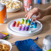 Colorful magnetic toy on a wooden table with snacks and drinks in the background