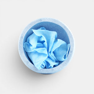 Blue Laura's play cotton in a matching blue container on a light gray background