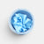 Blue Laura's play cotton in a matching blue container on a light gray background