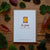 Card with 'Aspen' branding surrounded by leaves on a wooden surface