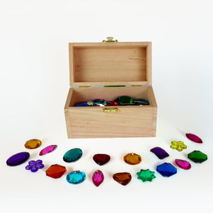 Wooden box with colorful gemstones on a white background