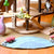 A wooden fairy house playset with a multi-level treehouse structure made of natural wood poles and platforms, featuring small felted wool gnomes, a pink felted wool bird, and a blue felted wool rug on a wooden floor.
