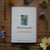 Card titled 'Heartsease' surrounded by flowers on a wooden surface