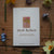 Card with 'Herb Robert' design surrounded by flowers on a wooden surface