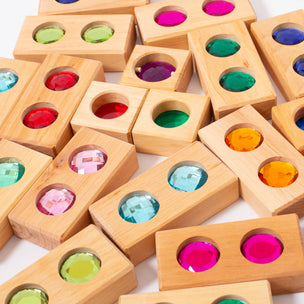 Wooden blocks with colored gems inside on a white background