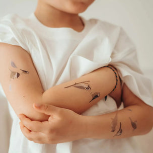 Bird tattoos on arms of boy