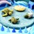 Model of a turtle life cycle on a blue surface with arrows indicating the stages.