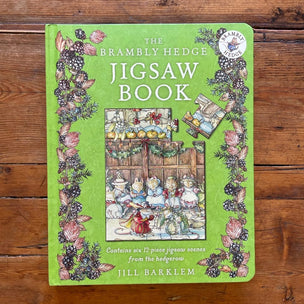 Green 'Brambly Hedge Jigsaw Book' on a wooden surface