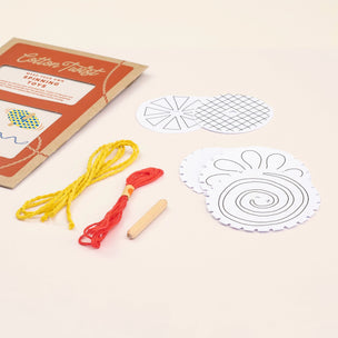 Spinning top kit with cardboard box, strings, and templates on a beige background