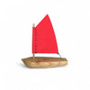 Wooden toy sailboat with a red sail on a white background