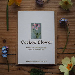 Card titled 'Cuckoo Flower' surrounded by flowers on a wooden surface