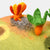 Felted landscape with a sunflower and carrot on a white background