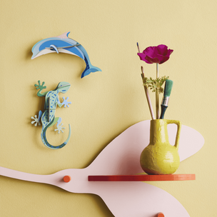 Decorative wall shelf with a vase, flowers, and animal figurines on a yellow background