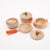 Set of wooden toy cookware with orange handles on a white background