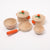 Set of wooden toy cookware with orange handles on a white background
