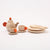 Wooden toy tea set with teapot, cups, and plates on a white background