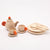 Wooden toy tea set with teapot, cups, and plates on a white background