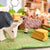 Wooden sheep toys on a green surface with a blurred indoor background