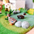 Wooden duck figures on a green felt background with small gray stones.