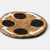 Round brown mat with black circles and white arrows on a light gray background