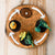 Round felt board with autumn-themed elements on a wooden surface