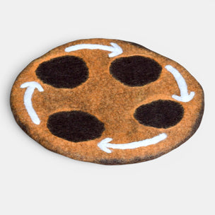 Round stone with a painted design resembling a face on a light gray background